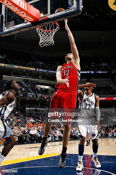 Rasho Nesterovic of the Toronto Raptors puts a shot up over DeMarre Carroll and Rudy Gay of the Memphis Grizzlies during the game on October 30, 2009...