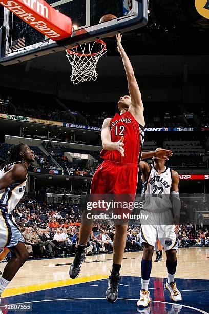 Rasho Nesterovic of the Toronto Raptors puts a shot up over DeMarre Carroll and Rudy Gay of the Memphis Grizzlies during the game on October 30, 2009...