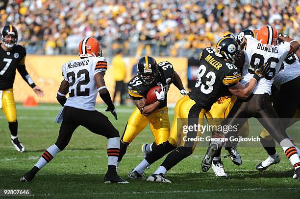 Running back Willie Parker of the Pittsburgh Steelers runs behind the blocking of tight end Heath Miller as cornerback Brandon McDonald of the...