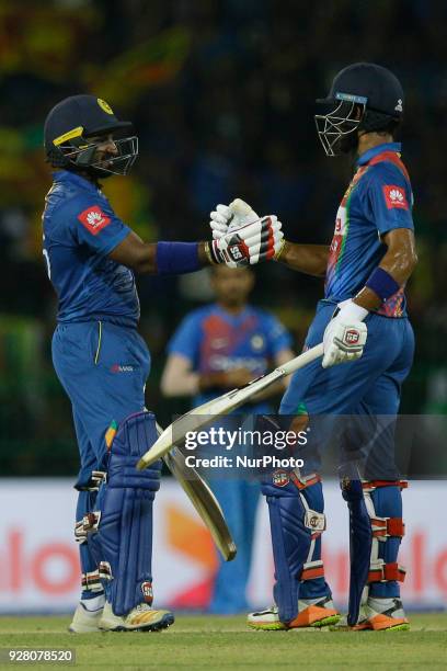 Sri Lanka cricketer Kusal Perera celebrates after scoring 50 runs as Sri Lankan cricket captain Dinesh Chandimal congratulates him during the 1st T20...