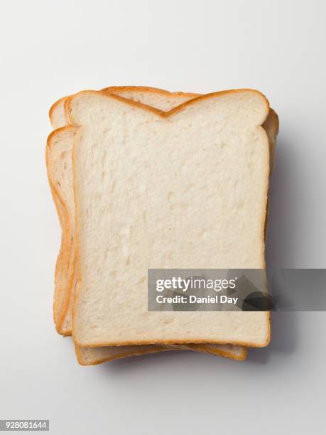 series of different sliced white bread slices, some with butter, crust and pile of slices against a white background shot from above - white bread stockfoto's en -beelden