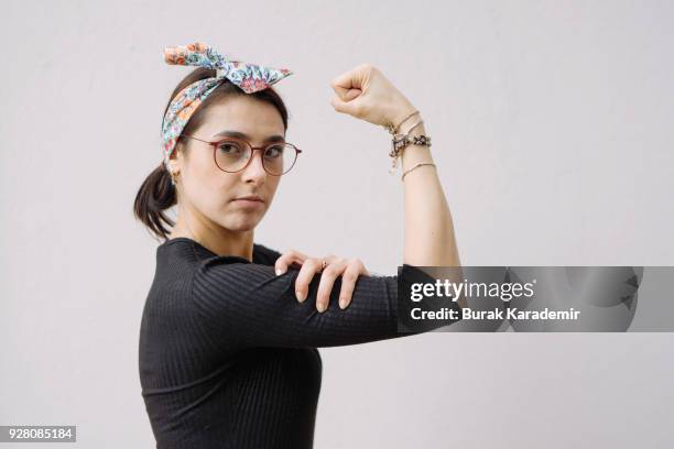 young woman shows her strong arm - rolled up sleeves stock pictures, royalty-free photos & images
