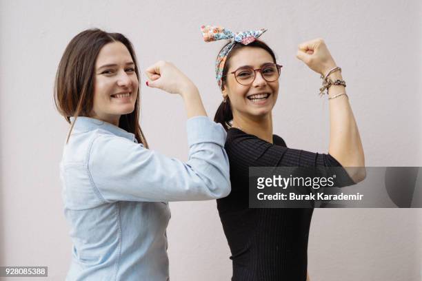 two young women show their strong arms - female exhibitionist fotografías e imágenes de stock
