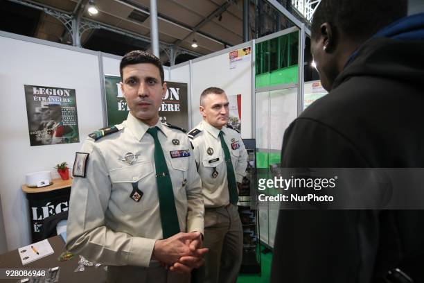 Jobseeker talks with members of French Foreign Legion recruiter staff at the &quot;Paris pour l'emploi&quot; recruitment forum on March 6 at the...