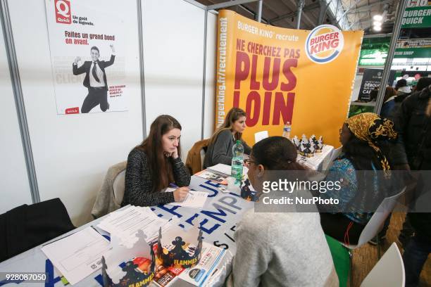 Jobseeker talks with a fast-foods members of recruitment services at the &quot;Paris pour l'emploi&quot; recruitment forum on March 6 at the Grande...