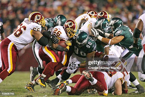 Defensive tackle Mike Patterson and linebacker Chris Gocong of the Philadelphia Eagles tackle running back Clinton Portis of the Washington Redskins...