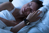 Woman Sleeping With Smart Watch Showing Heartbeat Rate