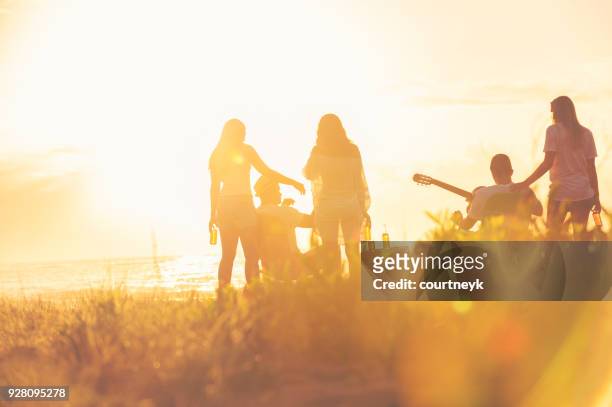 relaxed friends beach party at sunset with 5 people. - youth culture australia stock pictures, royalty-free photos & images