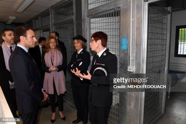 French president Emmanuel Macron flanked by French Justice Minister Nicole Belloubet listens at prison guard school director Sophie Bleuet during a...