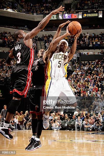Ford of the Indiana Pacers shoots under pressure against Mario Chalmers and Dwyane Wade of the Miami Heat during the game on October 30, 2009 at...