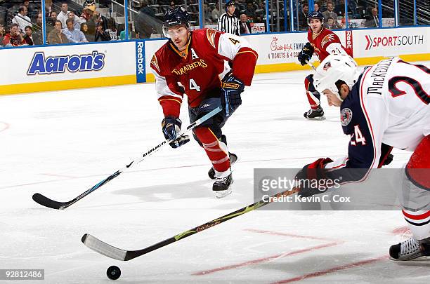 Derek MacKenzie of the Columbus Blue Jackets controls the puck against Zach Bogosian of the Atlanta Thrashers at Philips Arena on November 5, 2009 in...