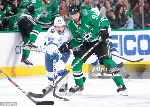 Tyler Seguin of the Dallas Stars tries to keep the puck away against Cory Conacher of the Tampa Bay Lightning at the American Airlines Center on...