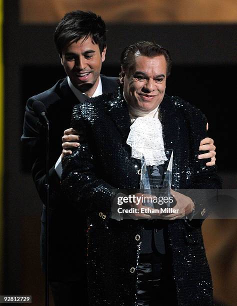 Singer Juan Gabriel accepts the Person of the Year award from singer Enrique Iglesias onstage during the 10th annual Latin GRAMMY Awards held at...