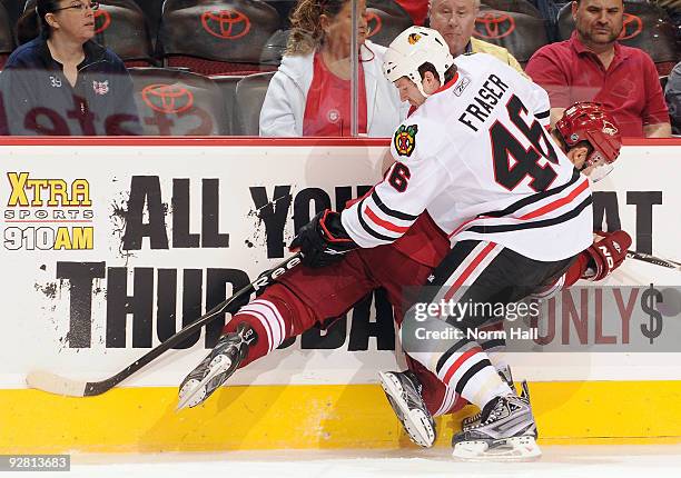 Colin Fraser of the Chicago Blackhawks checks Vernon Fiddler of the Phoenix Coyotes into the boards on November 5, 2009 at Jobing.com Arena in...