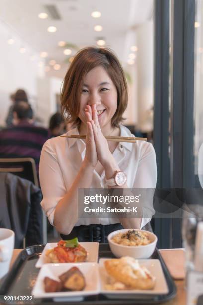young woman saying 'itadakimasu' just before eating lunch - itadakimasu stock pictures, royalty-free photos & images
