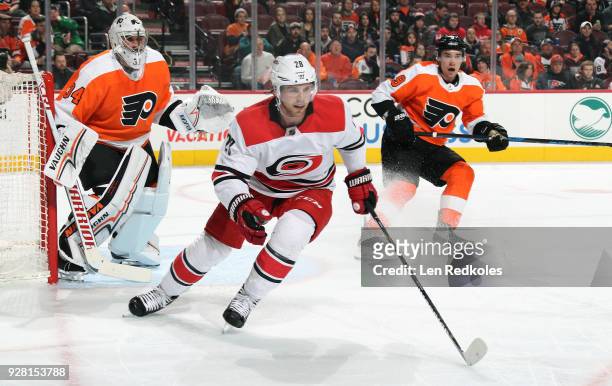 Elias Lindholm of the Carolina Hurricanes skates against Ivan Provorov and Petr Mrazek of the Philadelphia Flyers on March 1, 2018 at the Wells Fargo...