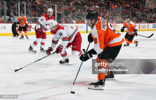 Ivan Provorov of the Philadelphia Flyers skates the puck in for a shot on goal against Elias Lindholm and Brett Pesce of the Carolina Hurricanes on...