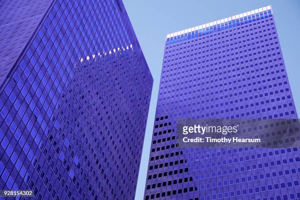close-up view of two city skyscrapers with reflections against a blue sky - timothy hearsum stock-fotos und bilder