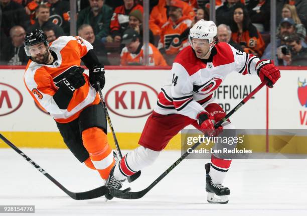 Justin Williams of the Carolina Hurricanes skates the puck against Radko Gudas of the Philadelphia Flyers on March 1, 2018 at the Wells Fargo Center...