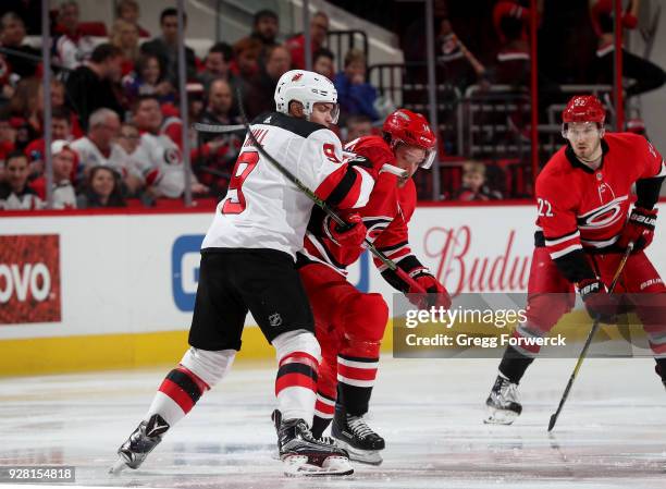 Justin Williams of the Carolina Hurricanes battles during a faceoff with Taylor Hall of the New Jersey Devils during an NHL game on March 2, 2018 at...