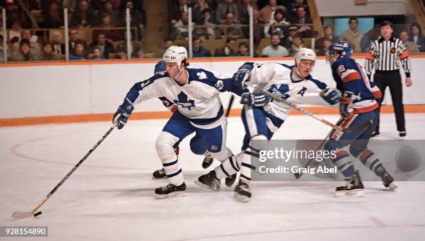 Al Iafrate and Borje Salming of the Toronto Maple Leafs skate against Pat LaFontaine of the New York Islanders during NHL game action on March 20,...