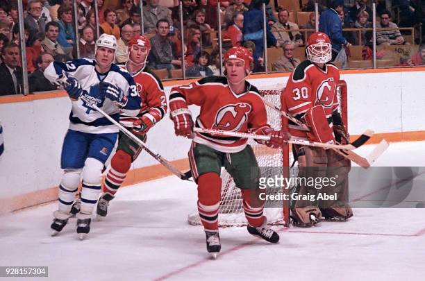 Rsndy Velisheck and Alain Chevrier of the New Jersey Devils skate against Steve Thomas the Toronto Maple Leafs during NHL game action on March 22,...