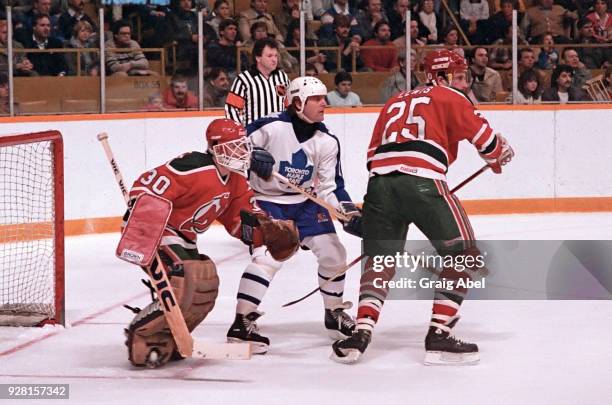 Alain Chevrier and Dave Lewis of the New Jersey Devils skate against Marian Stastny of the Toronto Maple Leafs during NHL game action on March 22,...