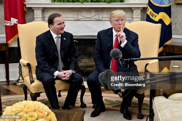 President Donald Trump, places his finger over his mouth before speaking during a meeting with Stefan Lofven, Sweden's prime minister, left, in the...