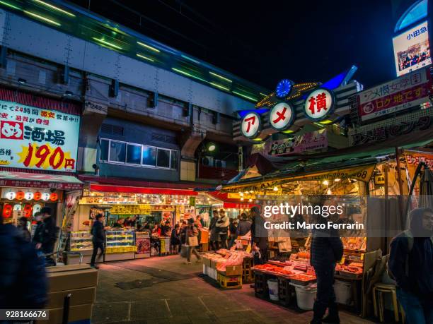 japanese city life at night, people walking along crowded shopping alley, ameya-yokocho - ameya yokocho fotografías e imágenes de stock