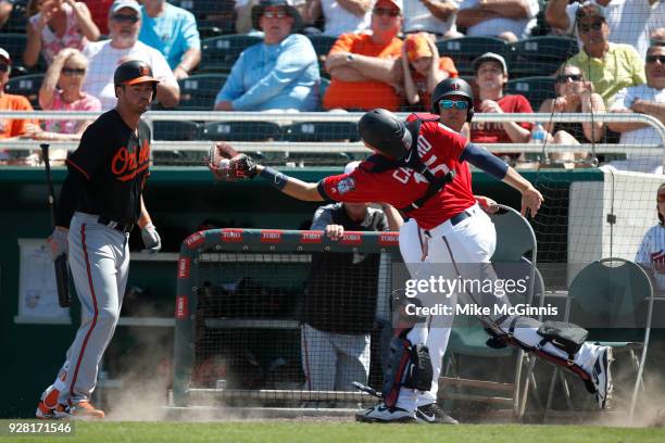 Jason Castro of the Minnesota Twins makes the grab in foul territory during the first inning of the Spring Training game against the Baltimore...