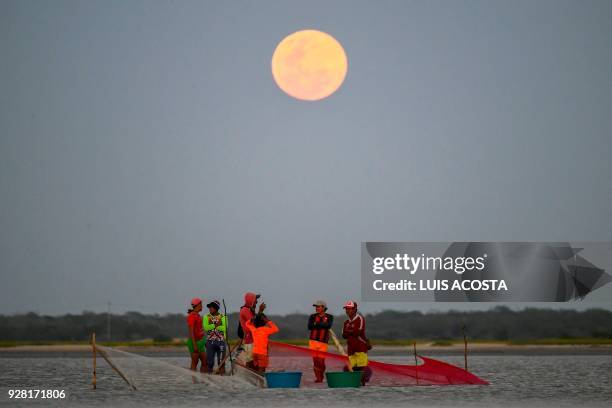 Fishermen fish shrimps under the full moon at the Navio Quebrado lagoon in the village of Boca de Camarones, Guajira Department, northern Colombia,...