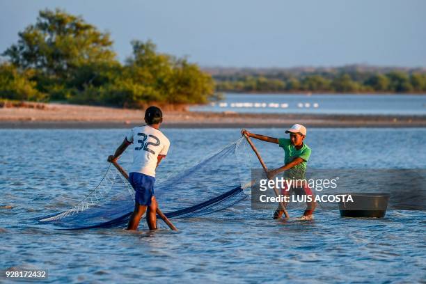 Young fishermen fish shrimps at the Navio Quebrado lagoon in the village of Boca de Camarones, Guajira Department, northern Colombia, on March 1...
