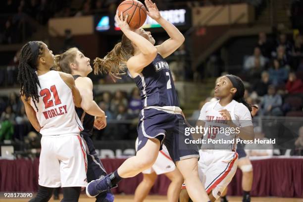 Brittni Lai of the University of New Hampshire puts up a shot between Aaliyah Worley, left, and Shania Johnson of Stony Brook during an American East...