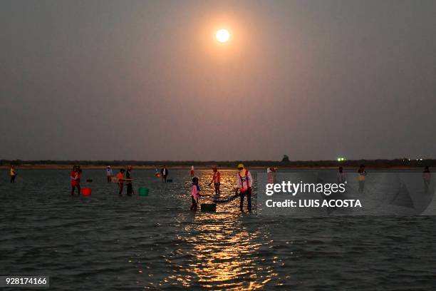 Fishermen fish shrimps under the full moon at the Navio Quebrado lagoon in the village of Boca de Camarones, Guajira Department, northern Colombia,...