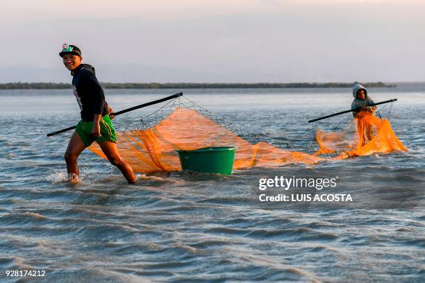 Young fishermen fish shrimps at the Navio Quebrado lagoon in the village of Boca de Camarones, Guajira Department, northern Colombia, on March 1...