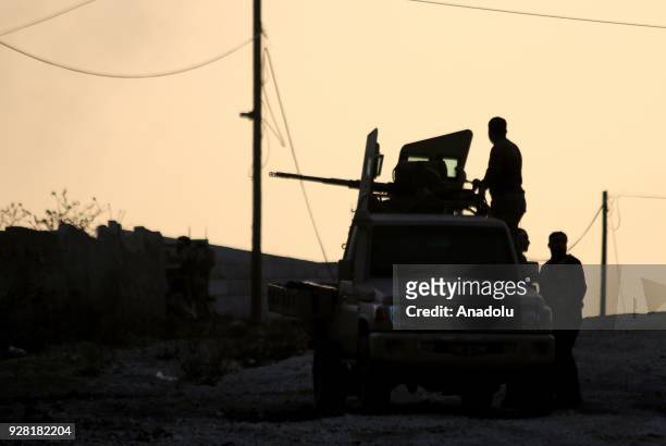 Silhouette of a soldier aiming with a gun loaded on back of a vehicle is seen after Free Syrian Army and Turkish Army liberate the village of Qatma...