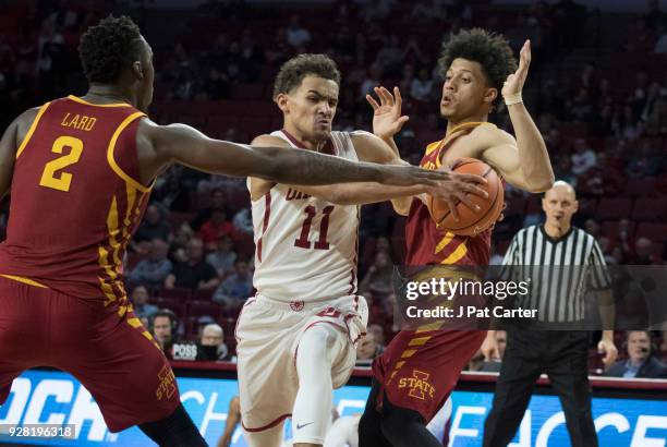 Trae Young of the Oklahoma Sooners drives through Iowa State players during the second half of a NCAA college basketball game at the Lloyd Noble...