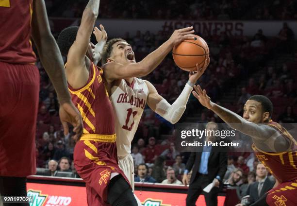 Trae Young of the Oklahoma Sooners shoots around Donovan Jackson of the Iowa State Cyclones during the second half of a NCAA college basketball game...