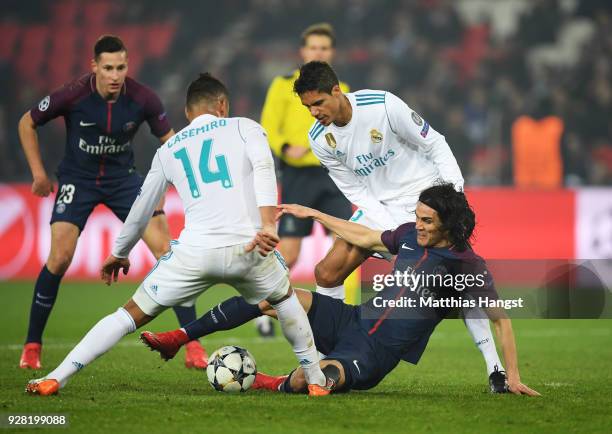 Edinson Cavani of PSG tangles with Casemiro and Raphael Varane of Real Madrid during the UEFA Champions League Round of 16 Second Leg match between...