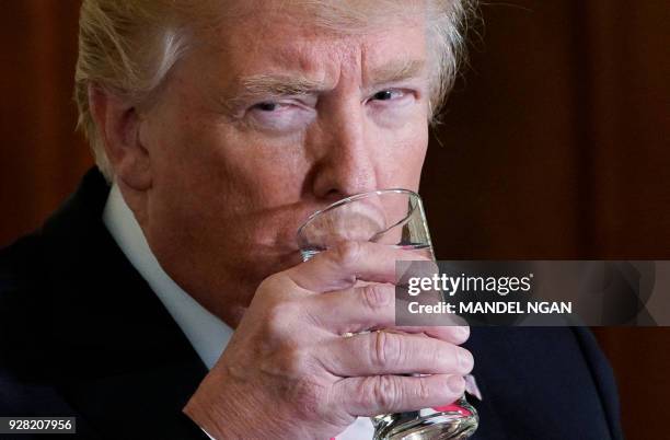 President Donald Trump takes a sip of water during a joint press conference with Sweden's Prime Minister Stefan Löfven in the East Room of the White...