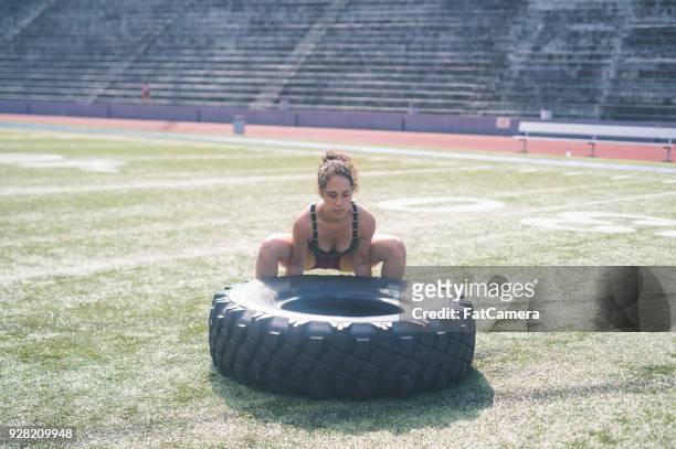 female athlete flipping giant tire at a stadium - giant camera stock pictures, royalty-free photos & images