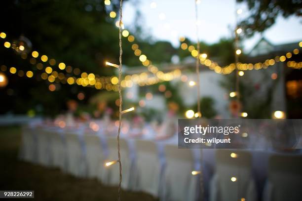 wedding string lights in focus at dusk - wedding reception stock pictures, royalty-free photos & images