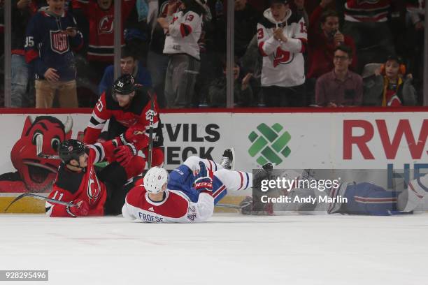 Brian Boyle of the New Jersey Devils celebrates his second period goal with Blake Coleman as he gets tangled up with Byron Froese of the Montreal...