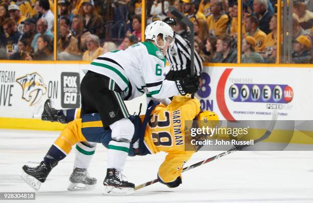 Julius Honka of the Dallas Stars cross checks Ryan Hartman of the Nashville Predators during an NHL game at Bridgestone Arena on March 6, 2018 in...