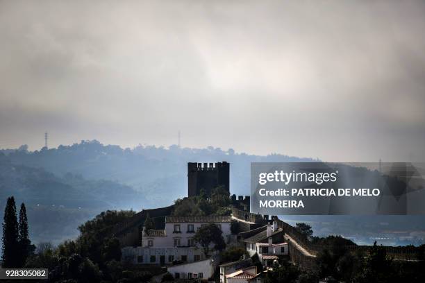 Picture shows the castle tower and surrounding walls of the medieval town of Obidos, central Portugal, on February 9, 2018. - To attract visitors to...