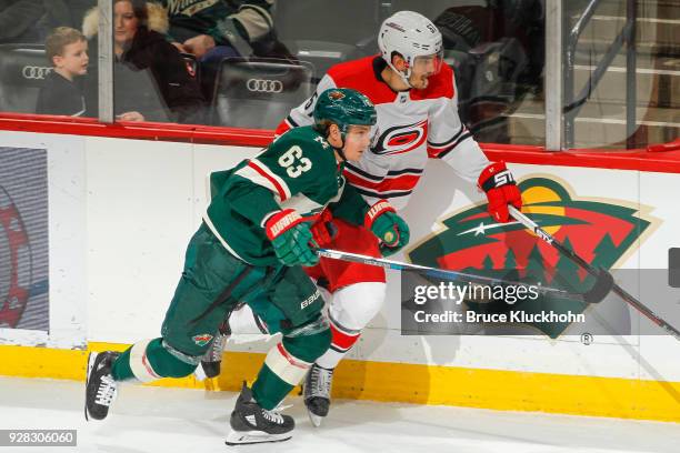 Tyler Ennis of the Minnesota Wild and Trevor van Riemsdyk of the Carolina Hurricanes skate to the puck during the game at the Xcel Energy Center on...