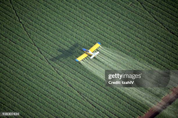 blick hinunter auf ein sprühflugzeug - feld flugzeug sprühen stock-fotos und bilder
