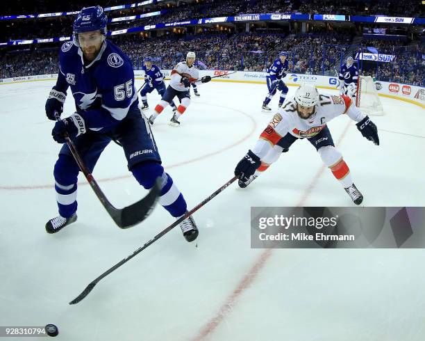 Braydon Coburn of the Tampa Bay Lightning and Derek MacKenzie of the Florida Panthers fight for the puck during a game at Amalie Arena on March 6,...