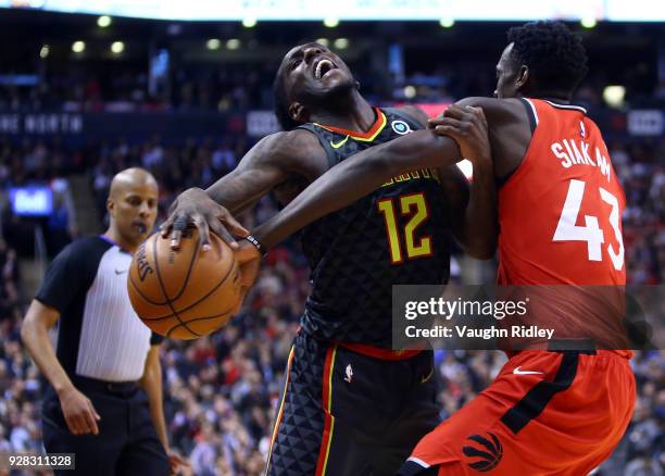 Taurean Prince of the Atlanta Hawks is fouled by Pascal Siakam of the Toronto Raptors during the second half of an NBA game at Air Canada Centre on...