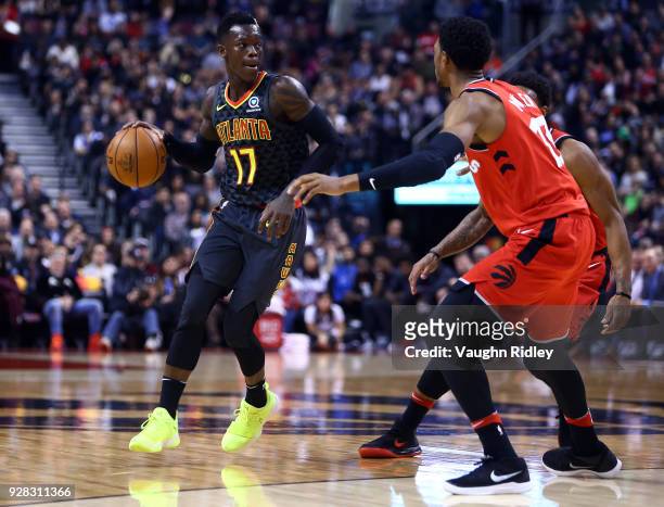 Dennis Schroder of the Atlanta Hawks dribbles the ball as Malcolm Miller of the Toronto Raptors defends during the second half of an NBA game at Air...